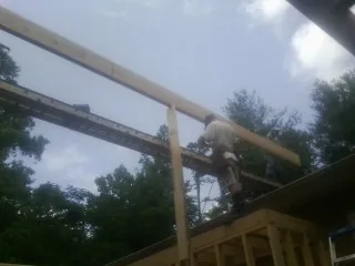 Carpenter setting a ridge beam over a new addition frame — Ice Dam Removal by Roofing Brothers in Rialto