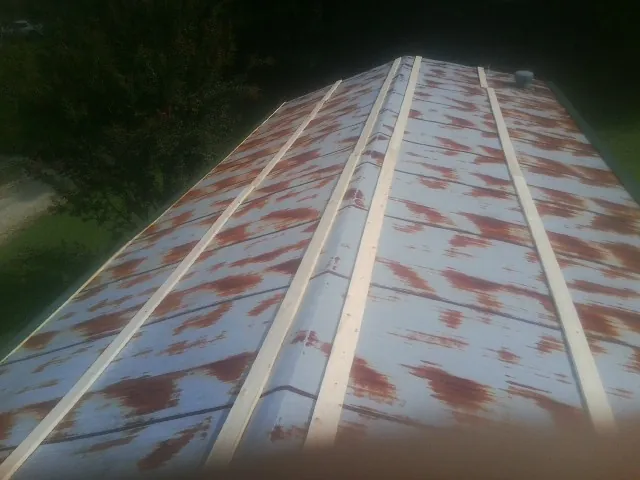 Rusted metal roof panels with new wood purlins before replacement — Storm Damage Roof Repair in Rialto by Roofing Brothers